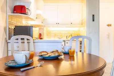 a table with a plate of food on top of it at LB Vacation Rentals I Cannes Croisette, Large Terrace, Free Parking, Beaches in Cannes