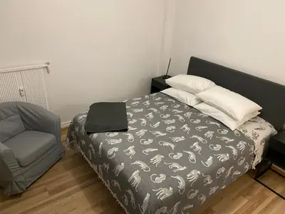 a bedroom with a bed and a chair with a laptop on it at Studio confortable 10 min du Palais des festivals in Cannes