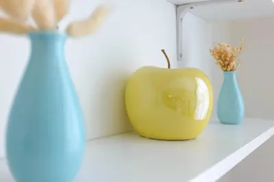 a yellow apple sitting next to two blue vases at Croisette Beach & Palace in Cannes