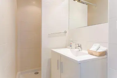 a white bathroom with a sink and a shower at Croisette Beach & Palace in Cannes
