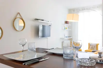 a wooden table with glasses and a plate on it at Croisette Beach & Palace in Cannes