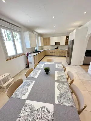 a large kitchen with a long table and chairs at Maison de ville tout confort à Cannes et à 10 Minutes à pied de la plage in Cannes