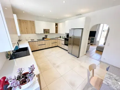 a large kitchen with a stainless steel refrigerator at Maison de ville tout confort à Cannes et à 10 Minutes à pied de la plage in Cannes