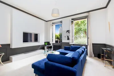 a living room with blue couches and a tv at Stylish Town House with 3 bedrooms and private parking in Cannes