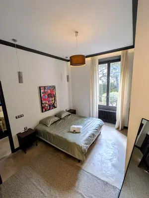 a bedroom with a bed and a large window at Stylish Town House with 3 bedrooms and private parking in Cannes