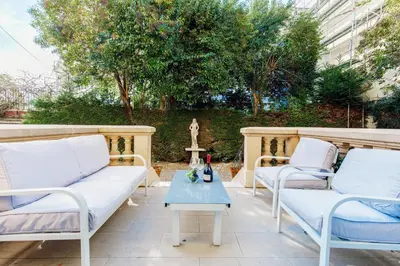 a patio with two white couches and a table at Stylish Town House with 3 bedrooms and private parking in Cannes