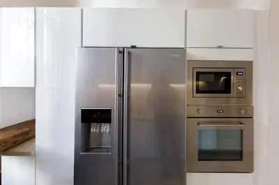 a kitchen with a stainless steel refrigerator and a microwave at Stylish Town House with 3 bedrooms and private parking in Cannes