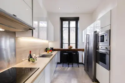 a kitchen with white counters and stainless steel appliances at Stylish Town House with 3 bedrooms and private parking in Cannes