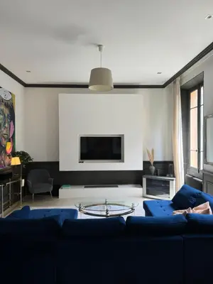 a living room with a blue couch and a tv at Stylish Town House with 3 bedrooms and private parking in Cannes