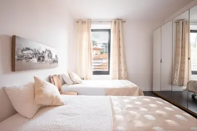 a white bedroom with two beds and a couch at L'EMPEREUR somptueux duplex au style raffiné, Petit Juas, proche du centre in Cannes