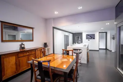 a dining room with a wooden table and chairs at L'EMPEREUR somptueux duplex au style raffiné, Petit Juas, proche du centre in Cannes