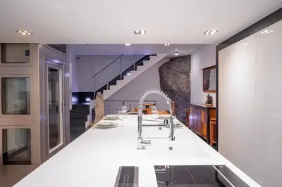 a dining room with a white table and a staircase at L'EMPEREUR somptueux duplex au style raffiné, Petit Juas, proche du centre in Cannes