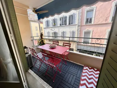 a balcony with a red table and chairs on it at Idéal Congrès - 1 min Mer - WIFI - hyper - centre in Cannes