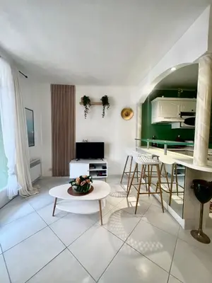 a living room with a table and a green wall at Idéal Congrès - 1 min Mer - WIFI - hyper - centre in Cannes