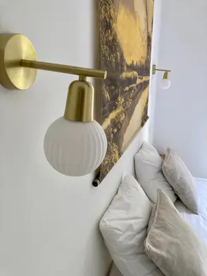 a lamp on a wall next to a bed with pillows at Cannes - L'Oustaou in Cannes