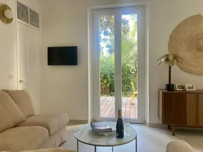 a living room with a couch and a table and a window at Cannes - L'Oustaou in Cannes