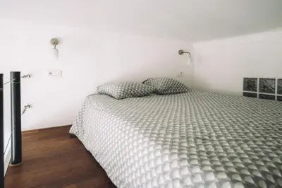 a bedroom with a bed in a white room at CANNES CENTRE VILLE- Bel appartement studio + Mezzanine in Cannes