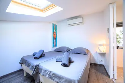 a bedroom with a bed with blue pillows on it at 21 Rue Meynadier - Meynadier Duplex in Cannes