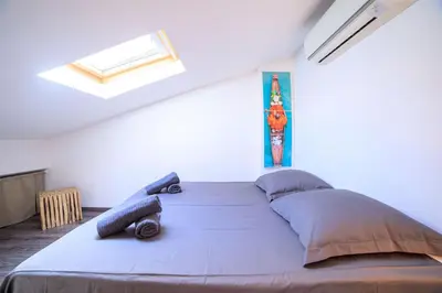 a bedroom with a large bed in a white room at 21 Rue Meynadier - Meynadier Duplex in Cannes