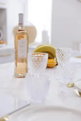 a bottle of alcohol sitting next to glasses on a counter at 21 Rue Meynadier - Meynadier 3p in Cannes