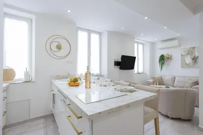 a white kitchen and living room with a large island at 21 Rue Meynadier - Meynadier 3p in Cannes