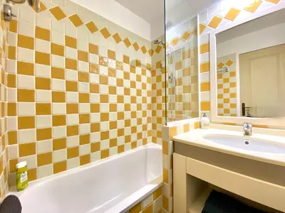 a bathroom with a sink and a tub and a mirror at Le Delacroix By SCLS Locations in Cannes
