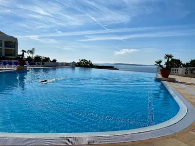 a large blue swimming pool with a person in the water at Le Delacroix By SCLS Locations in Cannes