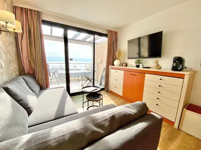 a living room with a couch and a large window at Le Delacroix By SCLS Locations in Cannes