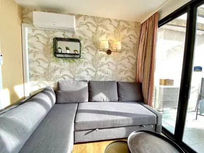 a couch in a room with a wall with a mirror at Le Delacroix By SCLS Locations in Cannes