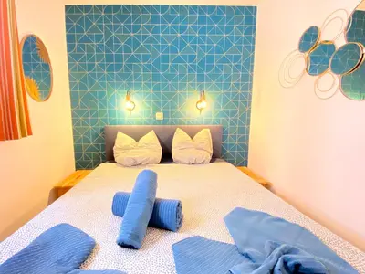 a bedroom with a bed with blue and white sheets at Le Delacroix By SCLS Locations in Cannes