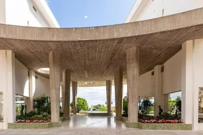 a large building with columns and flowers in a courtyard at Superbe 3 pièces avec piscine et tennis in Cannes