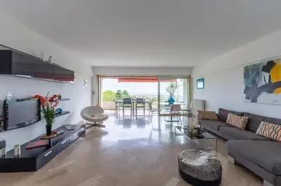 a living room with a couch and a table at Superbe 3 pièces avec piscine et tennis in Cannes