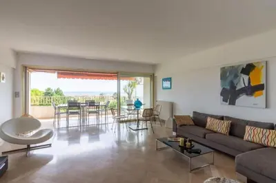 a living room with a couch and a table at Superbe 3 pièces avec piscine et tennis in Cannes