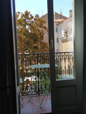 a door open to a balcony with a table at STUDIO CANNES A 5 MN A PIED DE LA GARE TOUT CONFORT AVEC BALCON in Cannes