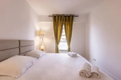 a bedroom with a large bed with towels on it at LB Vacation Rentals I High Floor Sea View 2Br Apt with Balcony & Garage in Cannes