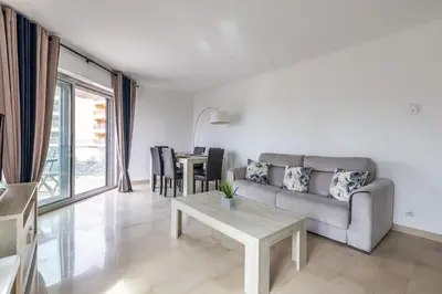 a living room with a couch and a table at LB Vacation Rentals I High Floor Sea View 2Br Apt with Balcony & Garage in Cannes