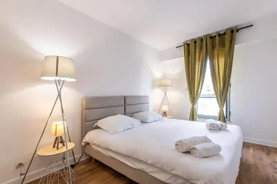 a bedroom with a bed with two towels on it at LB Vacation Rentals I High Floor Sea View 2Br Apt with Balcony & Garage in Cannes
