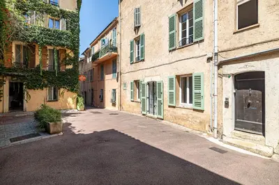 an empty alley in an old building with green shutters at L'EMERAUDE duplex confortable au cœur de Cannes, proche plage du Midi et Palais in Cannes