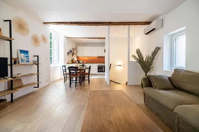 a living room with a couch and a table at L'EMERAUDE duplex confortable au cœur de Cannes, proche plage du Midi et Palais in Cannes