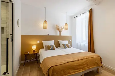 a bedroom with a bed and a window at L'EMERAUDE duplex confortable au cœur de Cannes, proche plage du Midi et Palais in Cannes