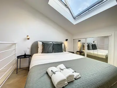 a bedroom with a large bed with towels on it at Cannes : Duplex à 5 minutes à pied du Palais des Festivals in Cannes
