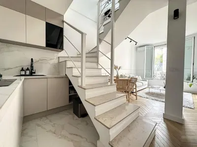 a white staircase in a kitchen with a living room at Cannes : Duplex à 5 minutes à pied du Palais des Festivals in Cannes