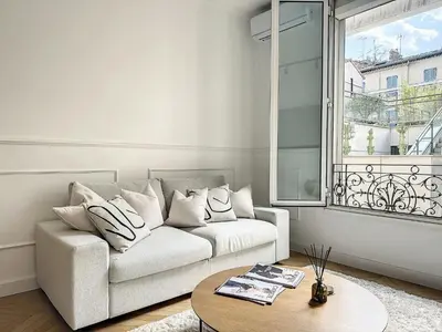 a white living room with a couch and a table at Cannes : Duplex à 5 minutes à pied du Palais des Festivals in Cannes