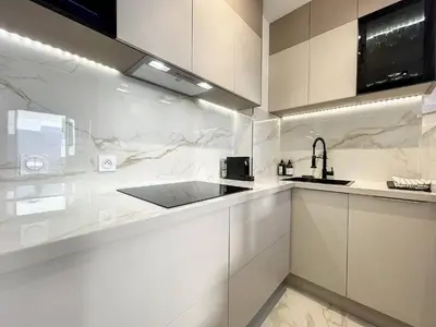 a kitchen with white cabinets and a sink at Cannes : Duplex à 5 minutes à pied du Palais des Festivals in Cannes