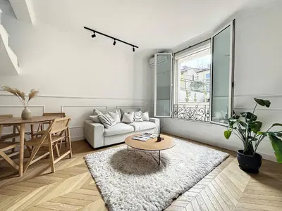 a living room with a white couch and a table at Cannes : Duplex à 5 minutes à pied du Palais des Festivals in Cannes