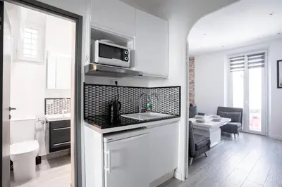 a white kitchen with a sink and a microwave at Cannes Experience Pastour Privatize 6 aparts 10bedrooms&9baths 11doublebeds with his duplexpenthouse ROOFTOP close palais congres beaches et Suquet in Cannes