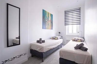 a white room with two beds and a mirror at Cannes Experience Pastour Privatize 6 aparts 10bedrooms&9baths 11doublebeds with his duplexpenthouse ROOFTOP close palais congres beaches et Suquet in Cannes