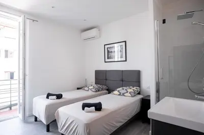 two beds in a room with a sink and a bathroom at Cannes Experience Pastour Privatize 6 aparts 10bedrooms&9baths 11doublebeds with his duplexpenthouse ROOFTOP close palais congres beaches et Suquet in Cannes