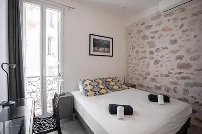 a small bedroom with two beds and a window at Cannes Experience Pastour Privatize 6 aparts 10bedrooms&9baths 11doublebeds with his duplexpenthouse ROOFTOP close palais congres beaches et Suquet in Cannes