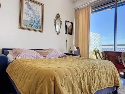 a bedroom with a bed with a yellow blanket on it at AGENCIA dernier étage vue mer panoramique in Cannes